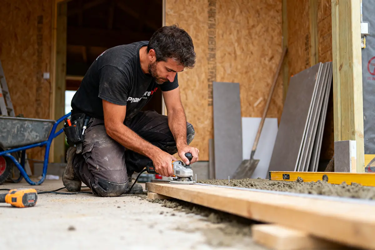 Un homme travaille du bois avec une scie électrique dans un chantier de construction.